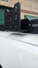 Heavy-duty steel canopy brackets installed on an AEGON roof rack for retractable shade mounting.