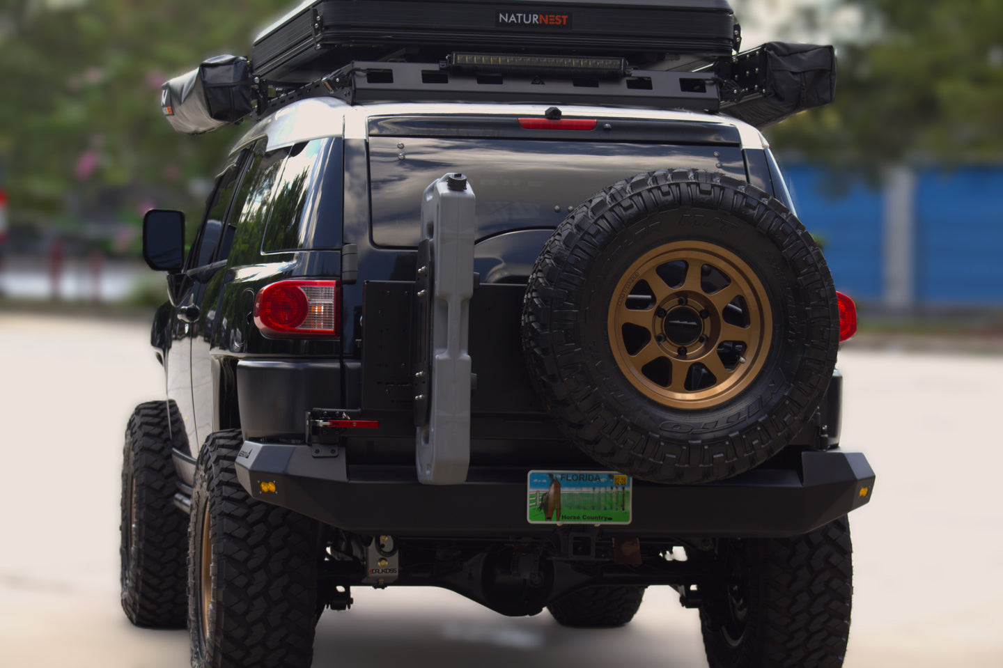 Fully built Toyota FJ Cruiser overland rig with AEGON rear bumper, spare tire carrier, and rooftop tent