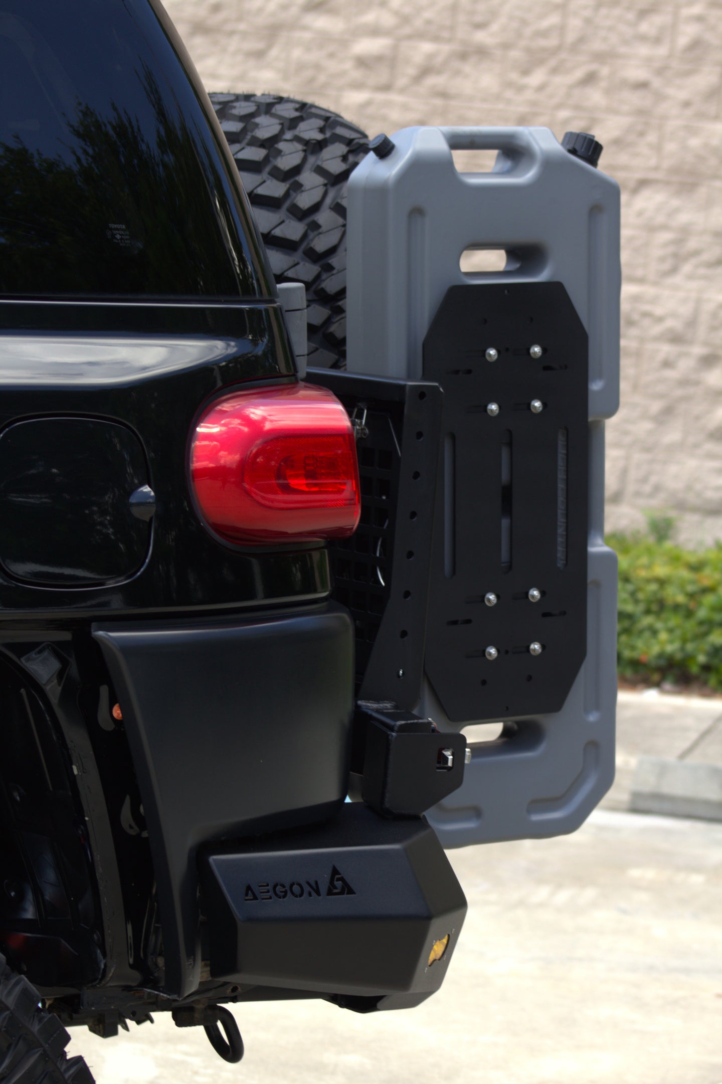 AEGON FJ Cruiser swing-out arm holding a fuel and water canister on the rear bumper