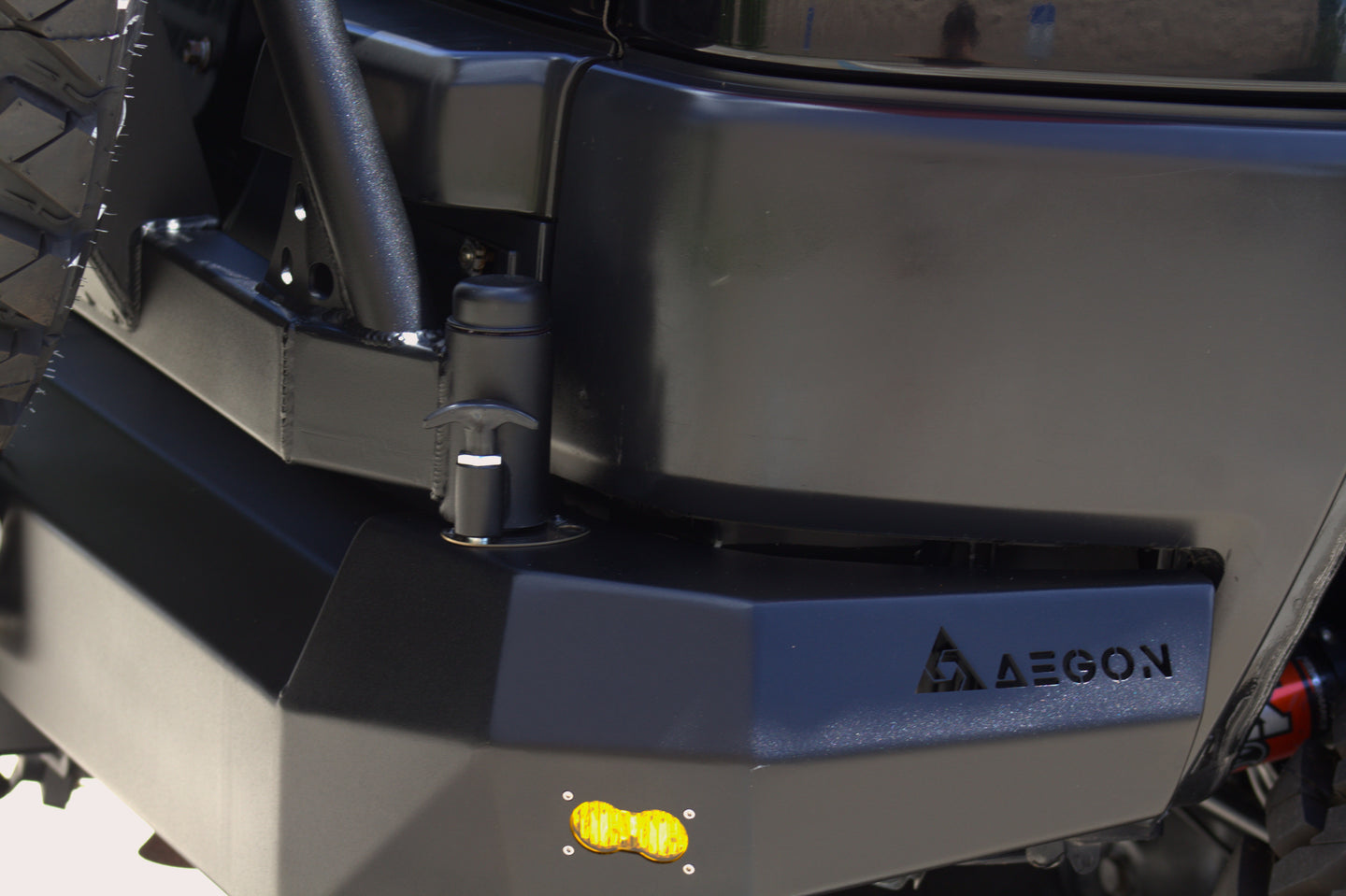 AEGON FJ Cruiser rear bumper hinge and pop-pin lock next to the AEGON logo and amber marker light