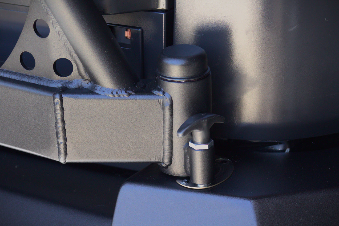 Detail of the welded hinge and locking pop-pin on the AEGON FJ Cruiser swing-out tire carrier