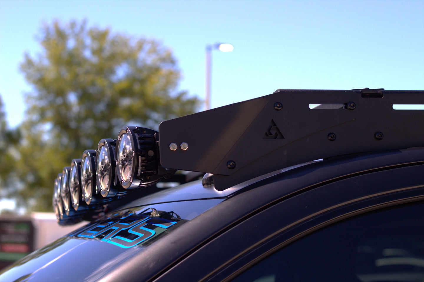 Sleek low-profile aluminum roof rack for GMC Sierra with integrated wind deflectors to reduce wind noise and drag.