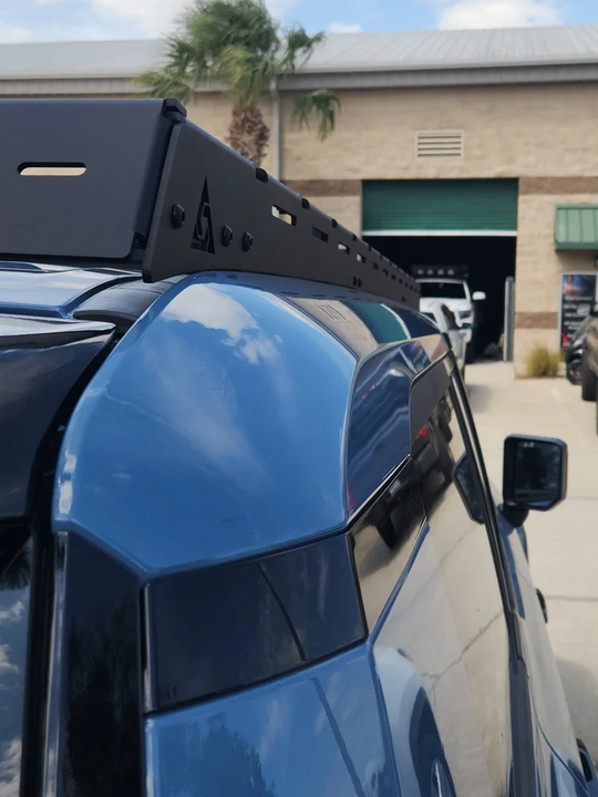 Sleek low-profile Land Cruiser 250 roof rack featuring integrated front light mounts and aerodynamic wind deflectors.