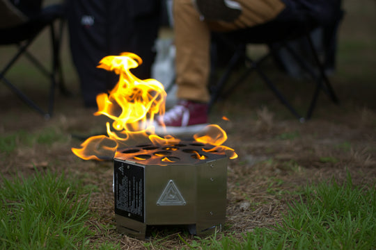 Outdoor camping setup featuring a portable propane fire pit next to an overland vehicle