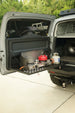 Aluminum drop down Molle table mounted on the rear door of a Toyota FJ Cruiser for organized cargo storage.
