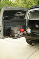 Aluminum drop down Molle table mounted on the rear door of a Toyota FJ Cruiser for organized cargo storage.